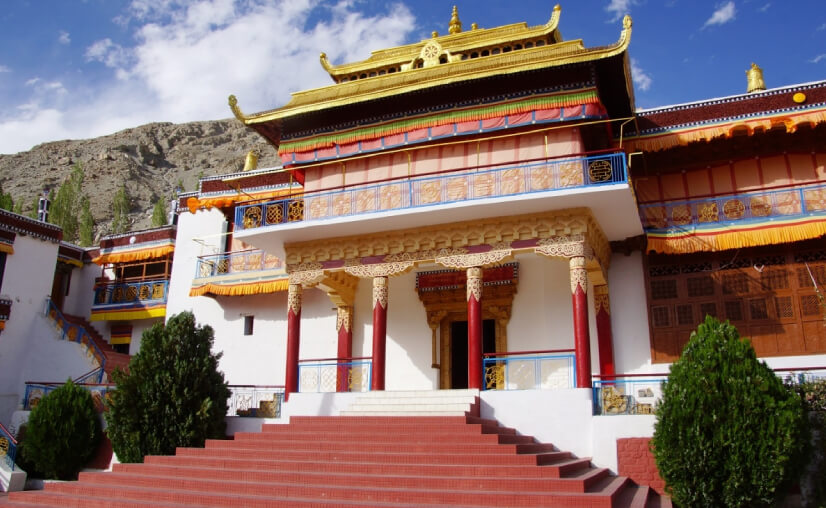 Interior detail of an assembly hall at Samstanling Monastery, showing painted murals along the wall